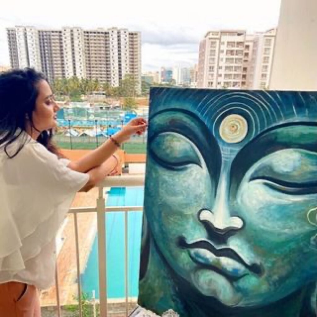 Malini Bedi painting a large Buddha canvas on her balcony studio